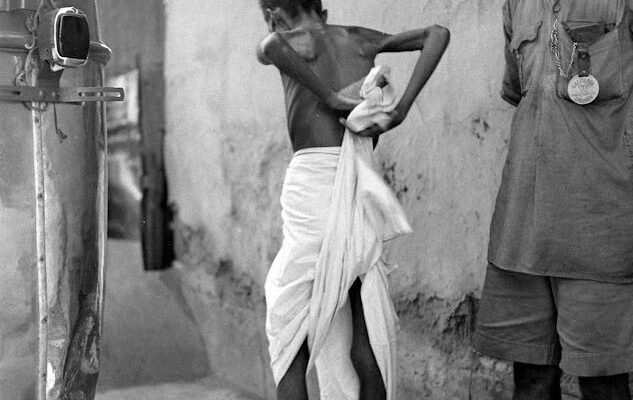 A famine affected man changing his cloth, credit: oldindianphotos